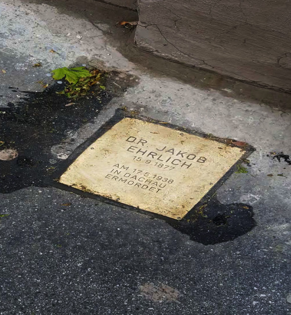 A Stolpersteine (“stumblestone”) plaque outside the building to honor a former inhabitant of the building who had been deported to Dachau and murdered in April 1938.