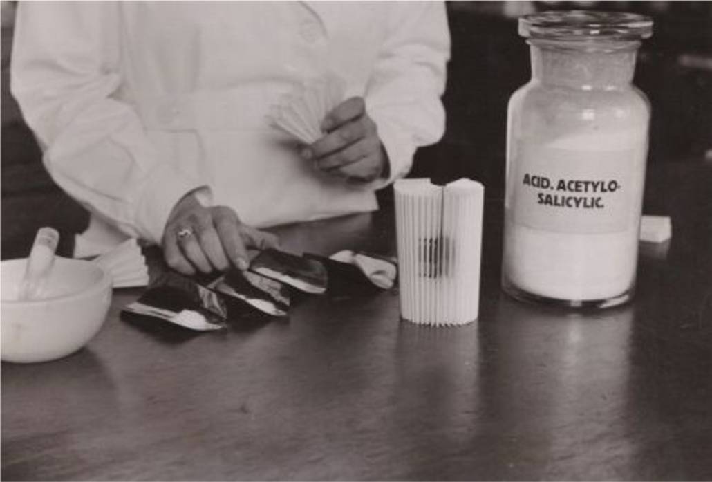 A pharmacist filling a paper fan with powdered medicine